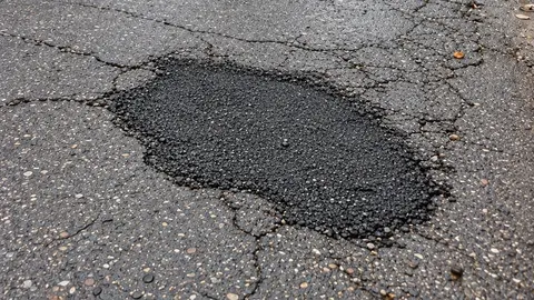 Foto del mismo bache, ya reparado con asfalto nuevo